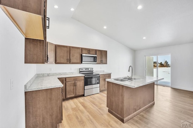 kitchen with stainless steel appliances, recessed lighting, a sink, an island with sink, and light wood-type flooring