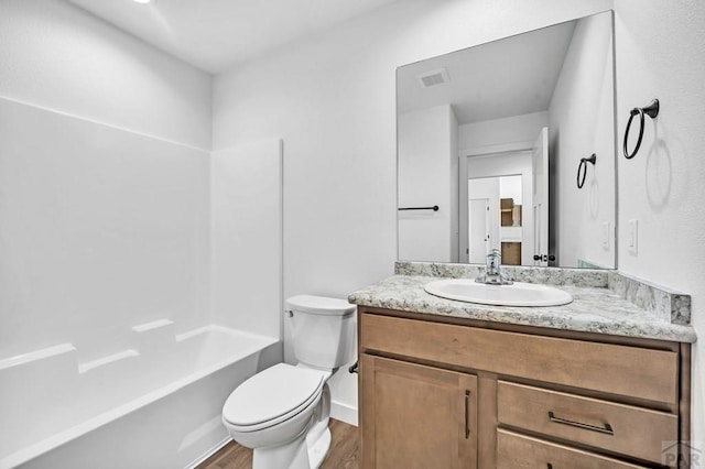 full bathroom with bathtub / shower combination, visible vents, toilet, vanity, and wood finished floors