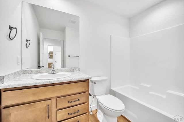 full bath featuring toilet, shower / bathing tub combination, wood finished floors, and vanity