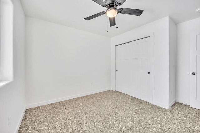 unfurnished bedroom featuring a closet, light colored carpet, and baseboards