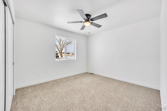 unfurnished bedroom featuring ceiling fan, a closet, carpet flooring, and baseboards