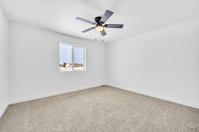 spare room featuring carpet floors, a ceiling fan, and baseboards