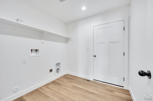 clothes washing area with baseboards, laundry area, washer hookup, and light wood-style floors