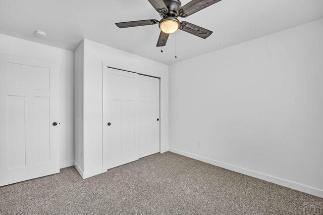 unfurnished bedroom featuring a ceiling fan, a closet, carpet flooring, and baseboards