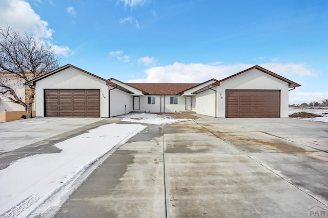 ranch-style house featuring an attached garage, driveway, and stucco siding