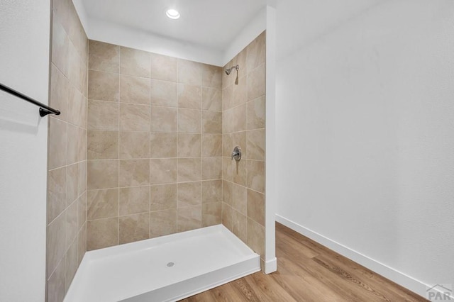 bathroom with a shower stall, baseboards, wood finished floors, and recessed lighting