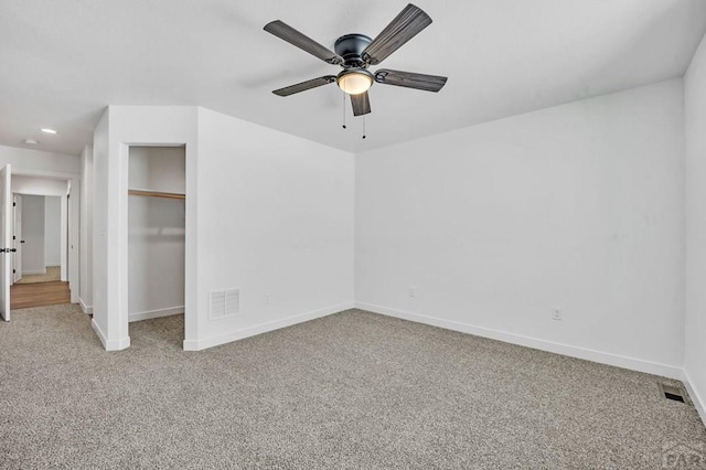 unfurnished bedroom with baseboards, visible vents, a ceiling fan, light colored carpet, and a closet