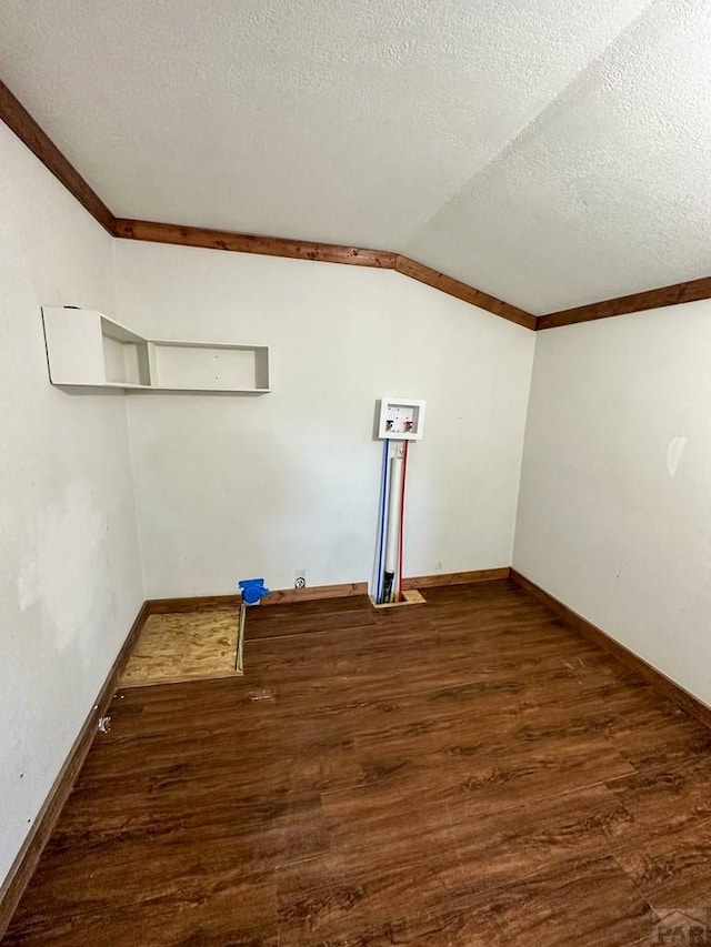 interior space featuring lofted ceiling, a textured ceiling, baseboards, and wood finished floors