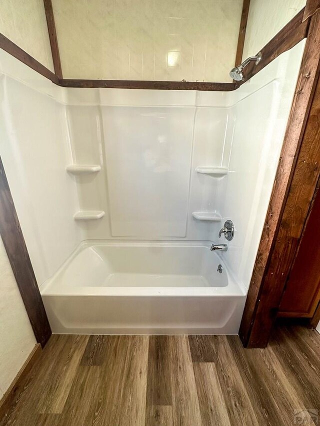 full bath featuring shower / bath combination and wood finished floors