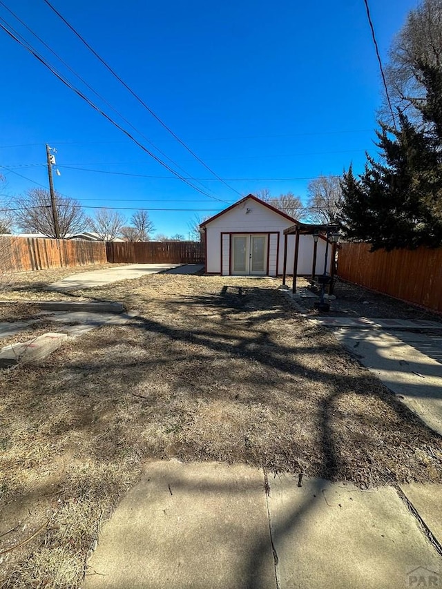 exterior space with a fenced backyard, a storage unit, and an outbuilding