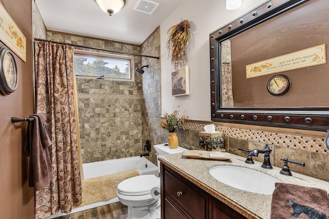 bathroom featuring visible vents, toilet, shower / tub combo with curtain, wood finished floors, and vanity