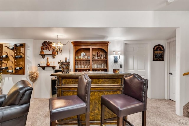 bar with a dry bar, an inviting chandelier, and carpet floors