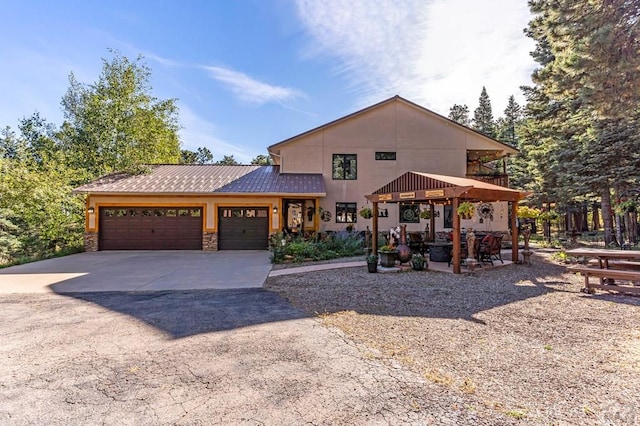 view of front facade with stucco siding, stone siding, concrete driveway, and an attached garage