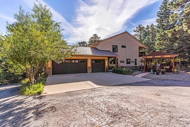 view of front of home with metal roof, a garage, stone siding, driveway, and a standing seam roof