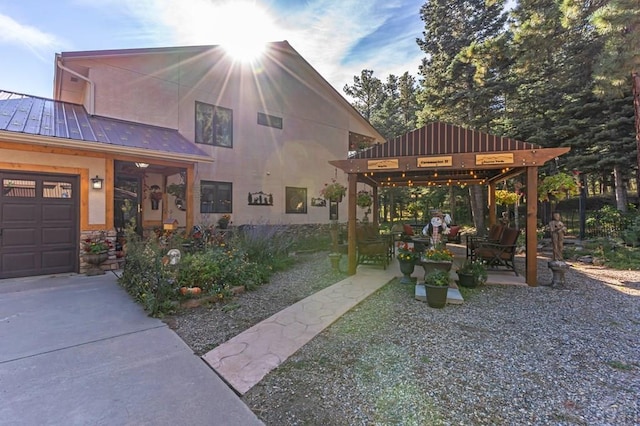 view of front of house featuring a patio, a standing seam roof, stucco siding, a gazebo, and metal roof