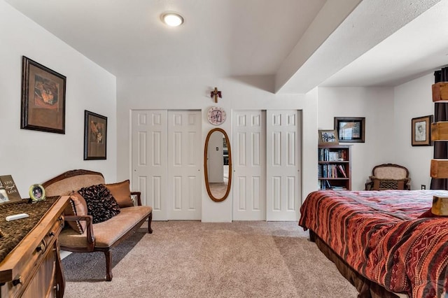 bedroom featuring two closets and light carpet