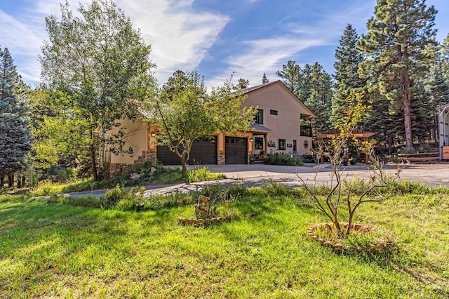 exterior space with stucco siding, stone siding, a garage, and concrete driveway