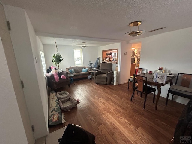 living room with visible vents, wood finished floors, and a textured ceiling