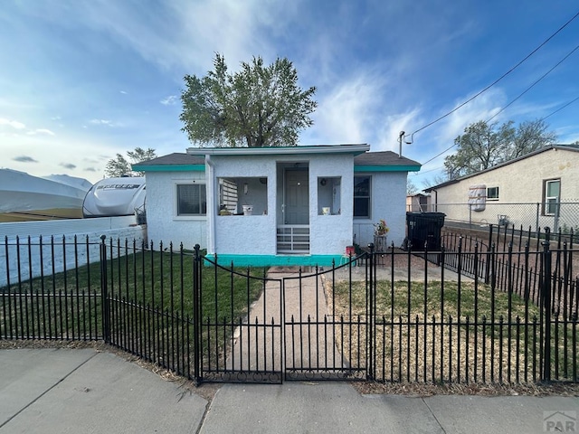 bungalow with a porch, stucco siding, a front lawn, and a fenced front yard