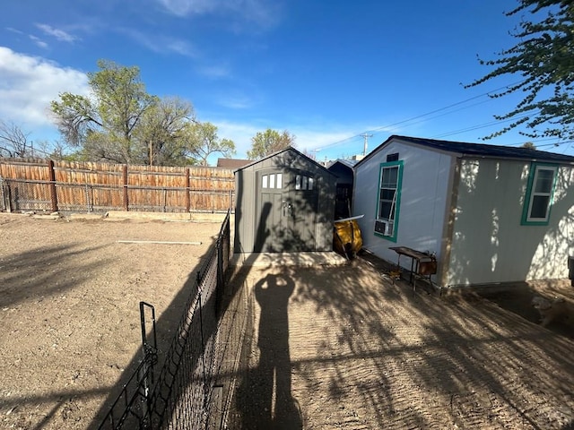 view of yard with an outbuilding, a fenced backyard, and a shed