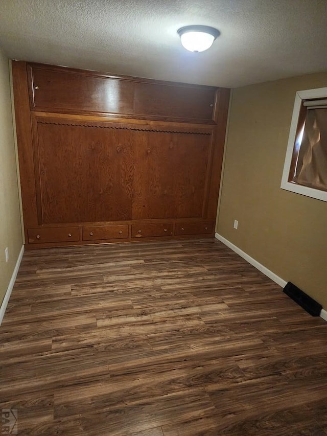 615 San Juan St, Trinidad, CO 81082 - unfurnished room with dark wood-style flooring and a textured ceiling