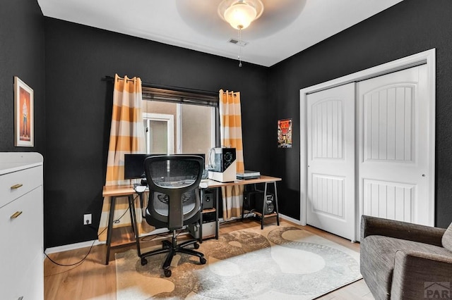 office featuring wood finished floors, baseboards, and ceiling fan