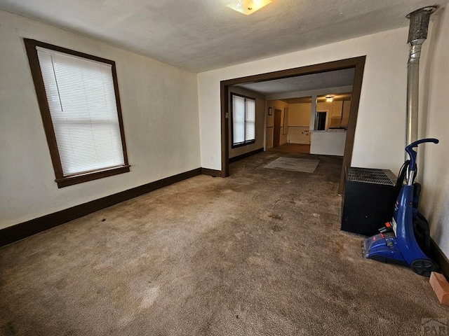 empty room with dark carpet and baseboards