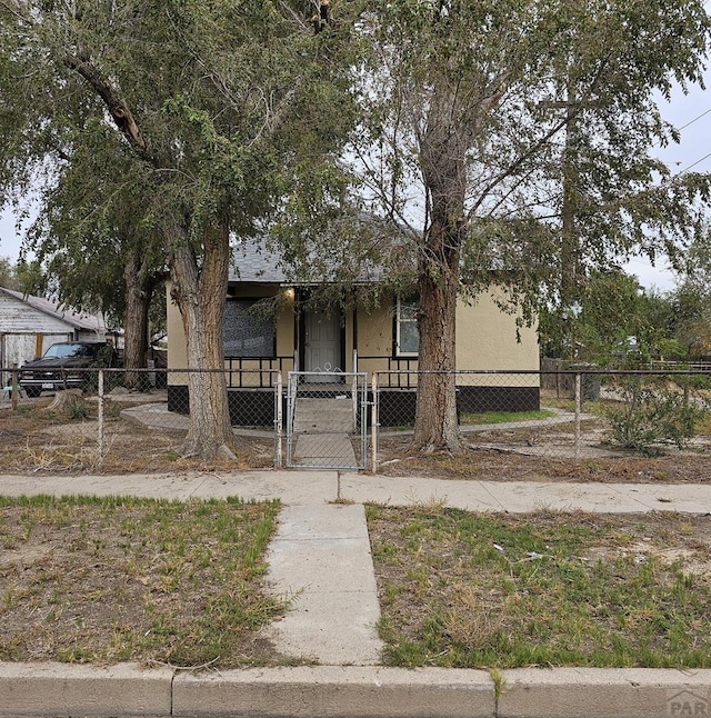 view of front of property featuring a fenced front yard, a gate, and stucco siding