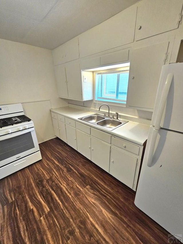 1337 Spruce St, Pueblo, CO 81004 - kitchen featuring white appliances, a sink, dark wood-style flooring, white cabinets, and light countertops