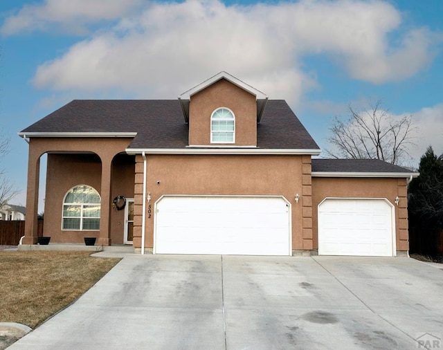 view of front facade featuring concrete driveway, an attached garage, and stucco siding