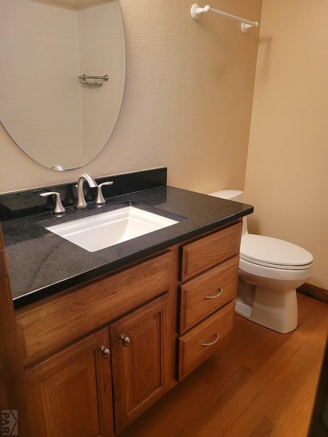 bathroom featuring toilet, wood finished floors, and vanity