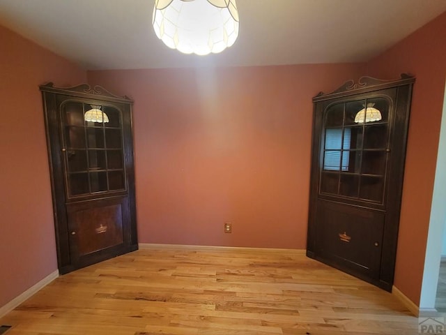 unfurnished dining area with light wood-style floors and baseboards