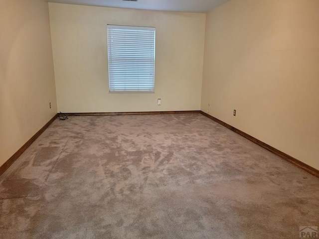 carpeted empty room with baseboards