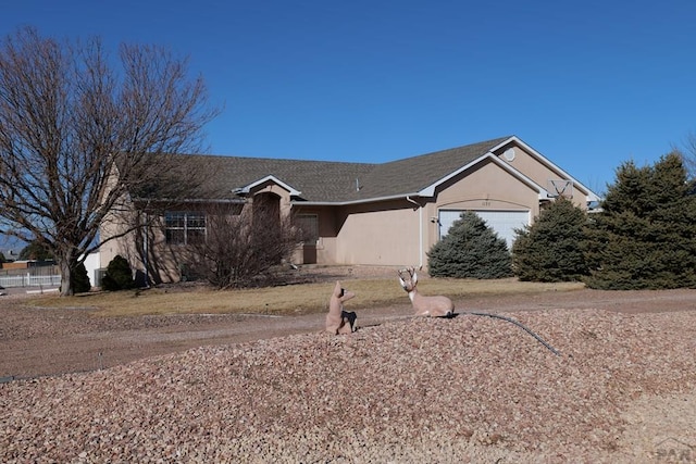 single story home featuring an attached garage and stucco siding