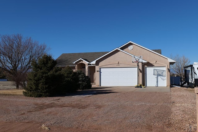 view of front facade with driveway, an attached garage, and stucco siding