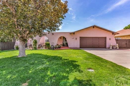 view of front of home with driveway, an attached garage, fence, and stucco siding