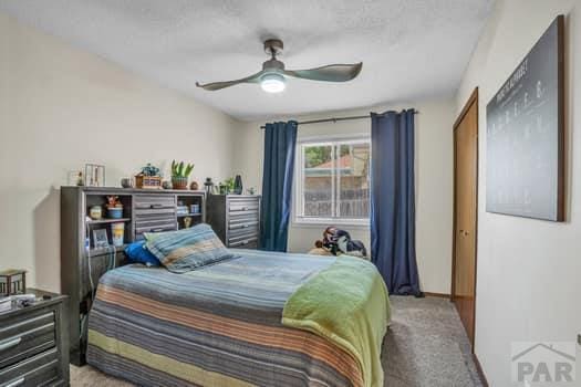 carpeted bedroom featuring ceiling fan and baseboards