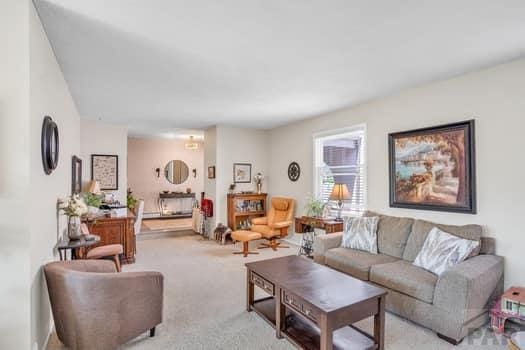 living room featuring light carpet and a fireplace