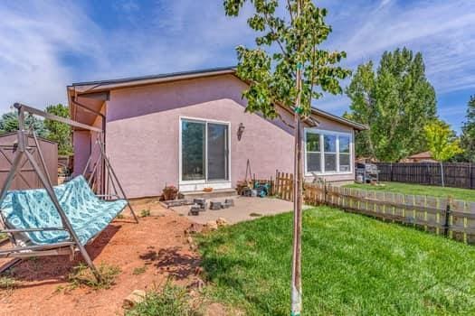 rear view of property with fence private yard, a yard, a patio, and stucco siding