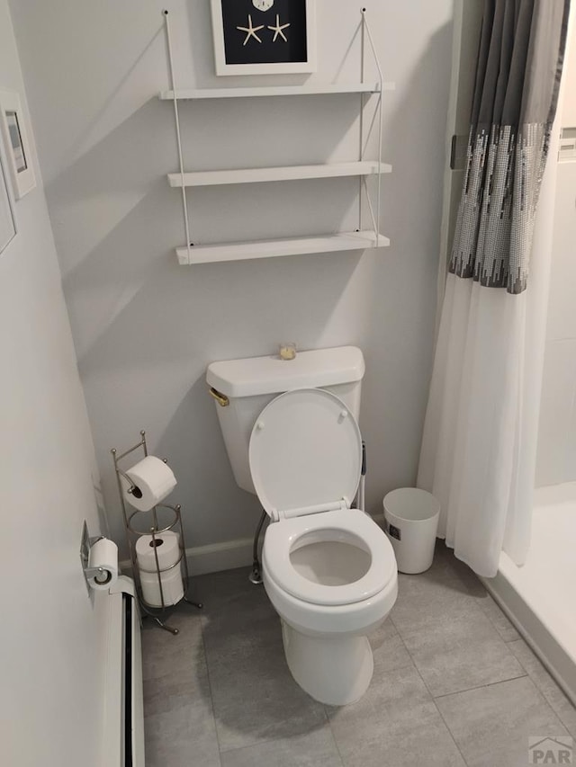 bathroom with toilet, a shower stall, and tile patterned floors