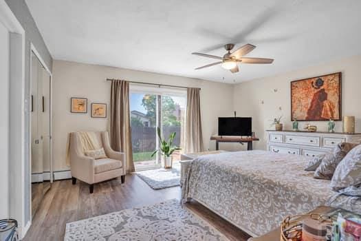 bedroom with ceiling fan, access to outside, baseboard heating, and light wood-style flooring