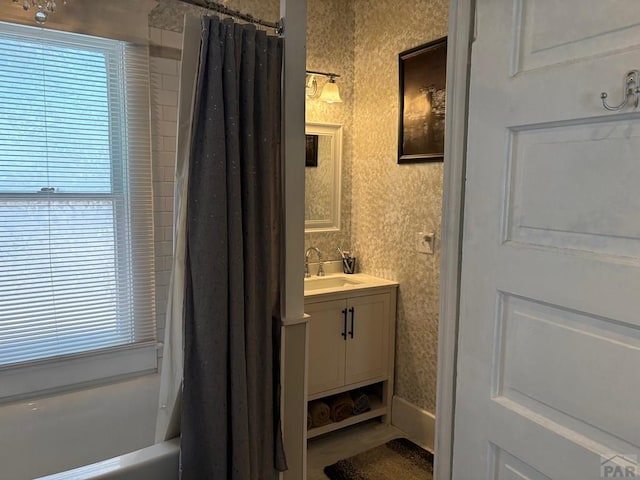 full bath featuring vanity, wallpapered walls, and shower / tub combo with curtain