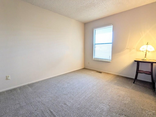 unfurnished room with baseboards, carpet flooring, and a textured ceiling