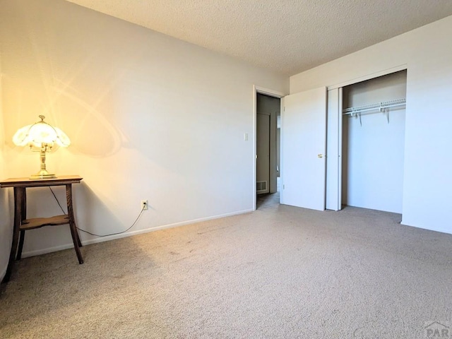 unfurnished bedroom featuring visible vents, a closet, a textured ceiling, and carpet floors