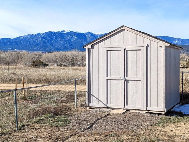 view of shed with a mountain view and fence