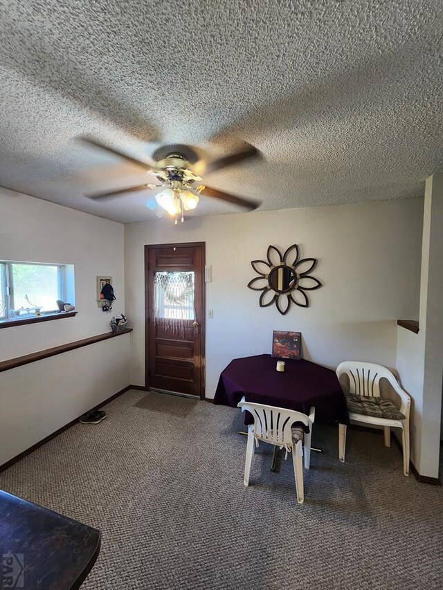 entrance foyer featuring a textured ceiling, carpet flooring, and ceiling fan