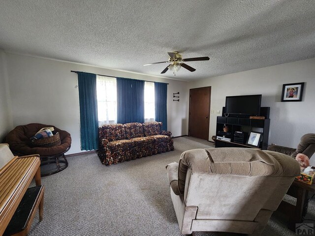 carpeted living area featuring ceiling fan and a textured ceiling