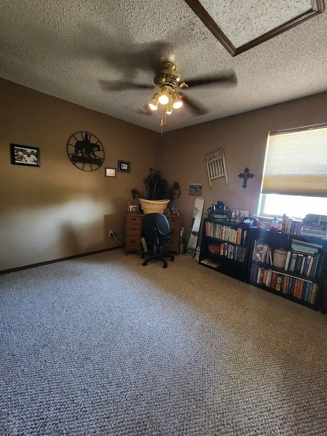 carpeted office featuring a textured ceiling and a ceiling fan