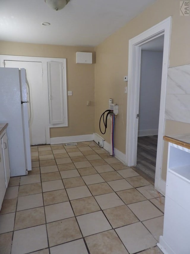 laundry room with baseboards and light tile patterned floors