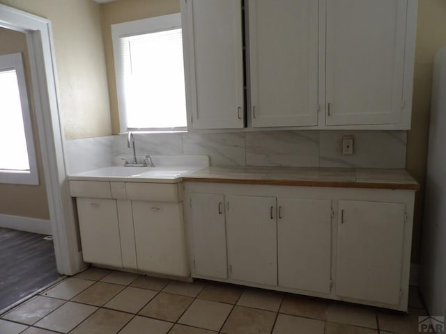 kitchen featuring a healthy amount of sunlight, white cabinets, and decorative backsplash